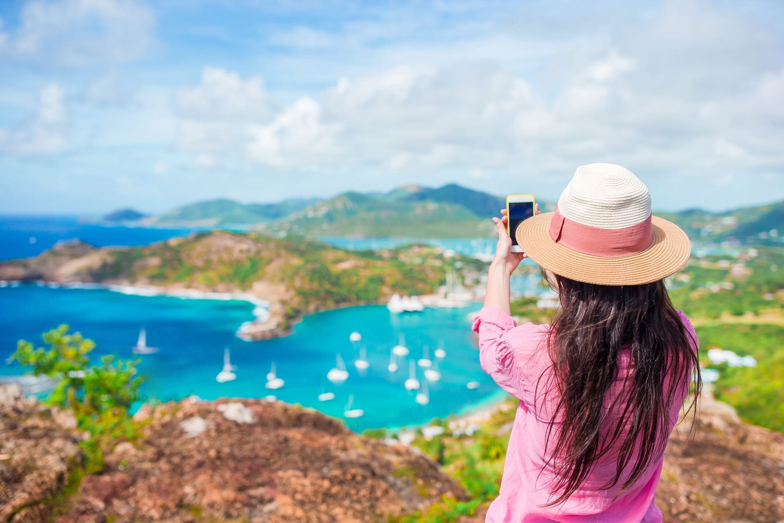 young-tourist-woman-making-photo-of-english-harbor-2023-11-27-05-36-58-utc-scaled