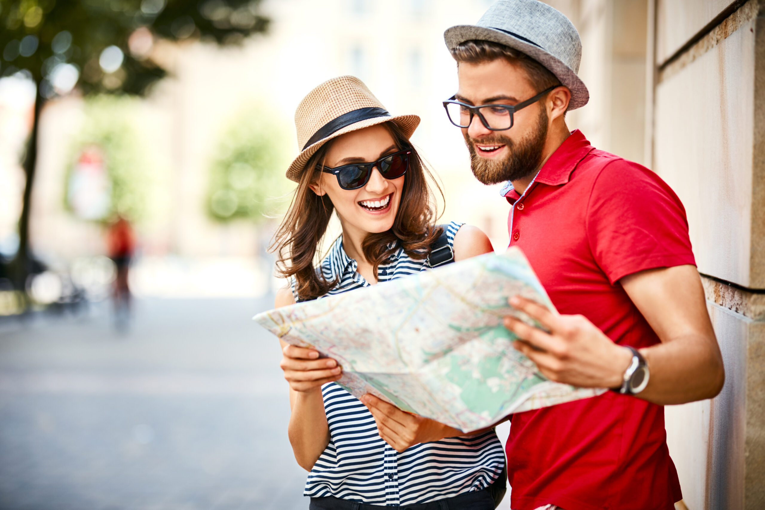 Young couple looking at map while on vacation during summer together